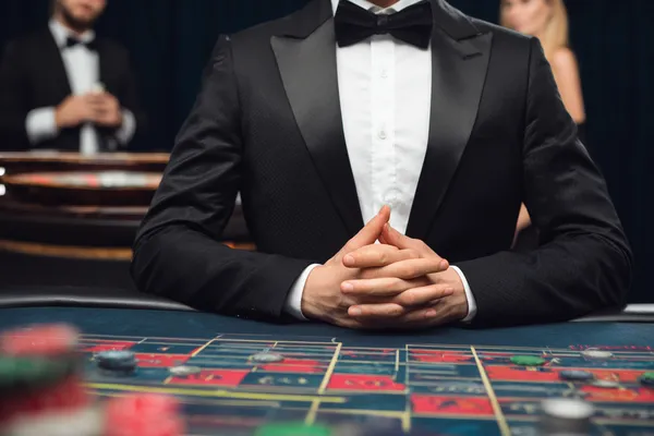 A woman in a luxurious green gown next to an ornate roulette wheel, capturing the upscale casino mood of ZEUS75.